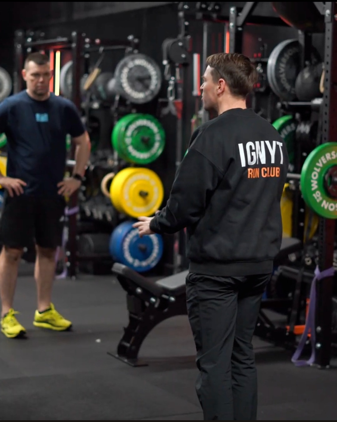 A coach speaking with members on the gym floor at IGNYT Fitness in Haverhill